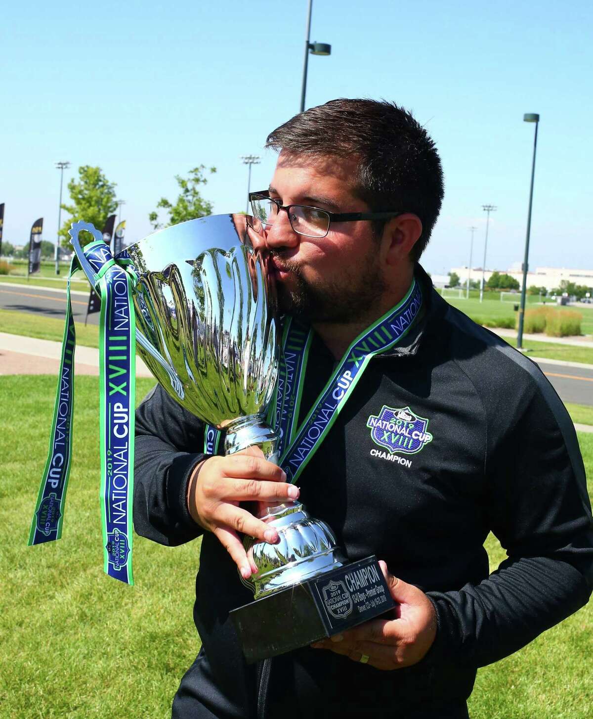 AC Connecticut U-13 coach Steve Carneiro with the National Cup trophy after his side won the title last week.