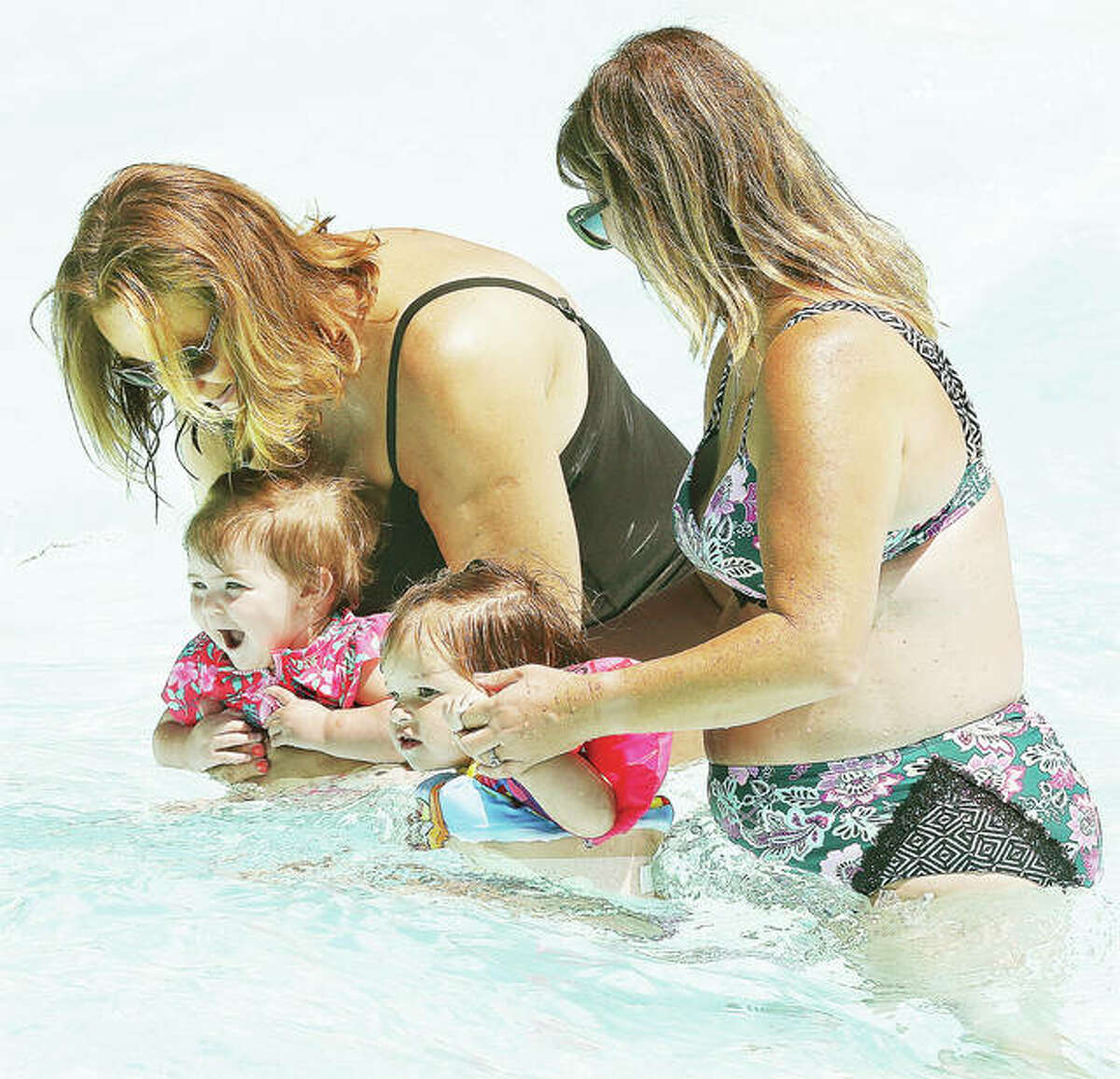 Two women entertain a couple of young children who seemed to be enjoying the water at Raging Rivers Waterpark in Grafton. Flooding forced the 28-acre park off Illinois 100, a popular attraction for the small town, to delay the start of its 30th year until July 3. The park has added hours and lengthened its season in response.