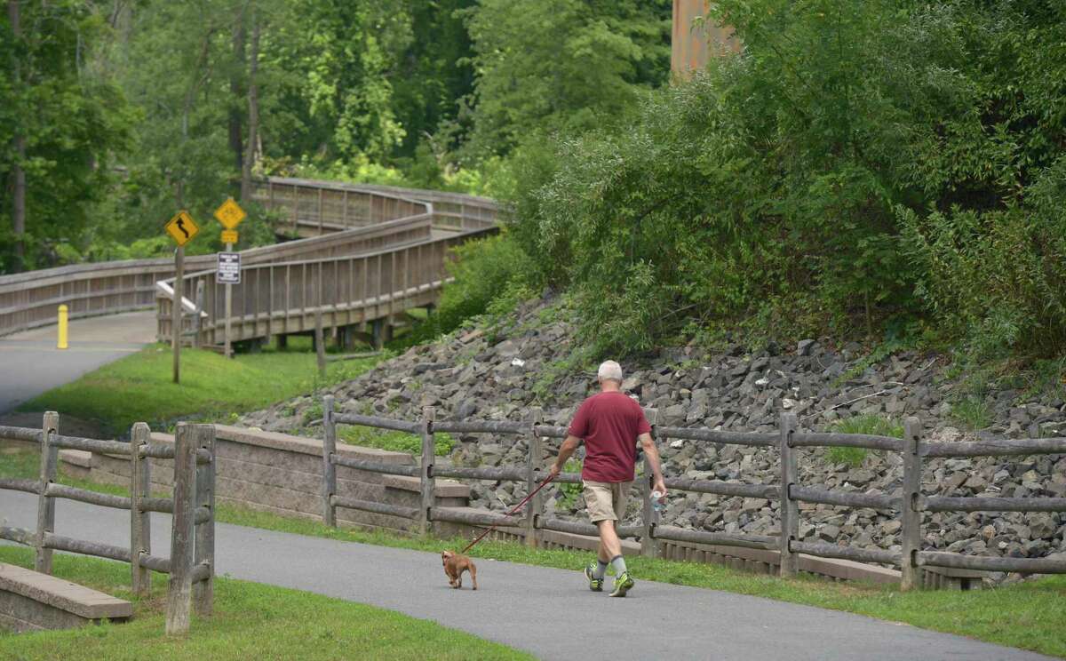 Barry Burgess, of New Milford, walks his dog Henry on Still River Greenway in Brookfield. The town is looking to extend the greenway to New Milford. Wednesday, July 24, 2019, in Brookfield, Conn.
