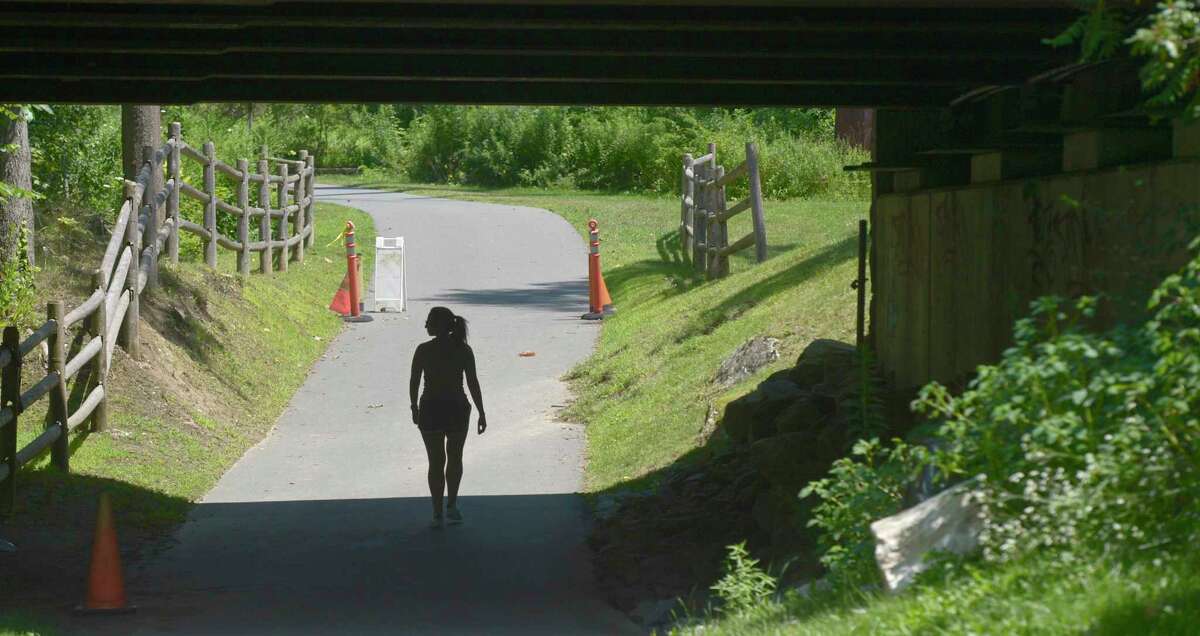 A walker passes under Route 7 while walking on the Still River Greenway in Brookfield. The town is looking to extend the greenway to New Milford. Wednesday, July 24, 2019, in Brookfield, Conn.