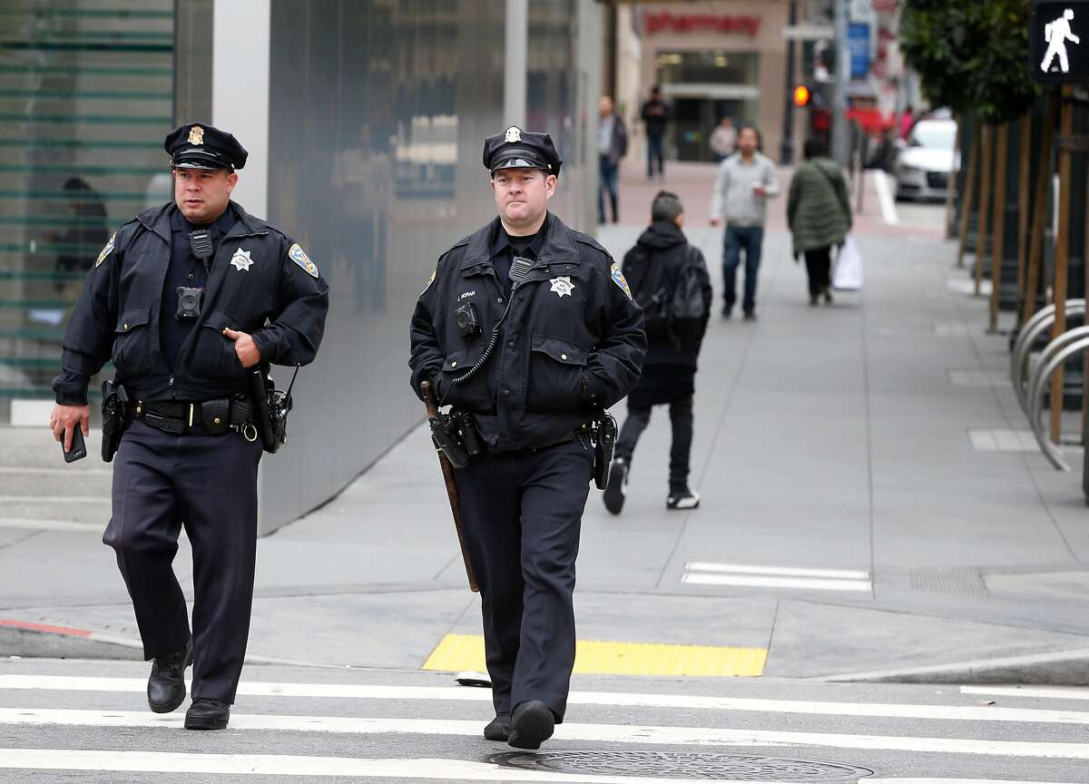 Two police officers walk on Stockton Street near Union Square in San Francisco, Calif. on Tuesday, Dec. 4, 2018.