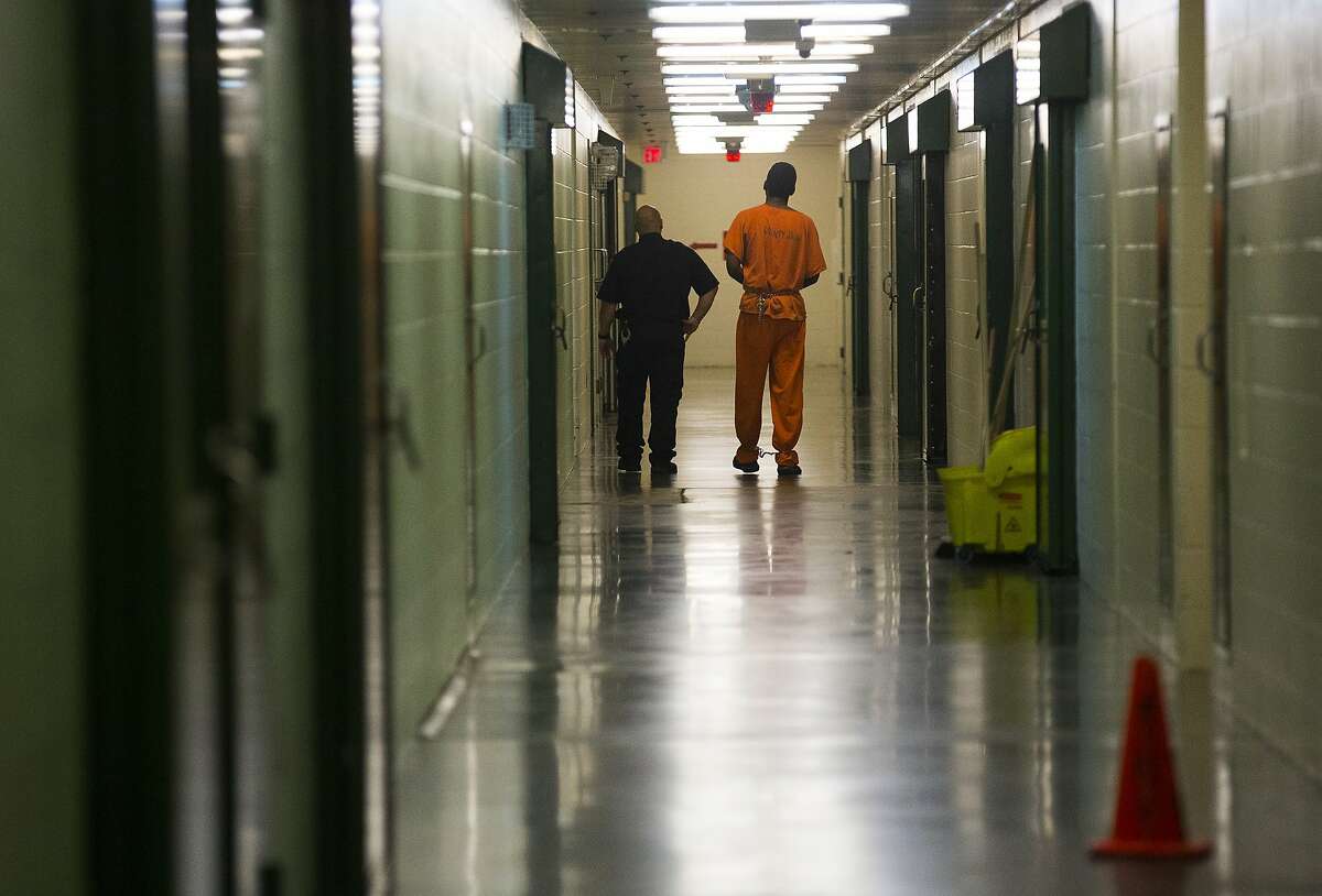 An inmate is escorted in a hallway in the Harris County jail, Thursday, March 29, 2018, in Houston.