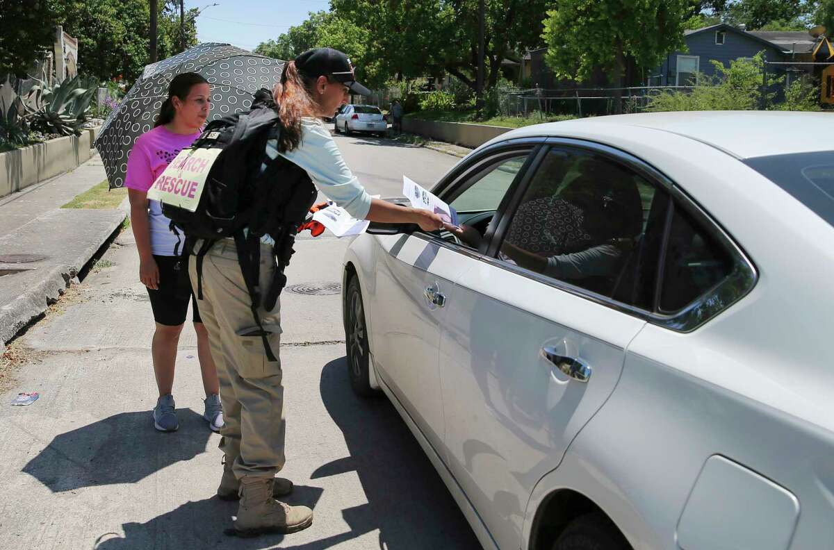 Search & Support San Antonio founder Nina Brooks (center) gives a flyer to a motorist as Mireya Lopez, sister of Cecilia Huerta Gallegos looks on during a search for Gallegos on Saturday, July 27, 2019. Gallegos, 30, was last seen in the 5600 block of Southwick Street on July 8, according to the San Antonio Police Department. On Saturday, about a dozen searchers including Gallegos' sister Mireya Lopez of Houston went to six different locations in an effort to draw to a close the disappearance of the mother of four children. (Kin Man Hui/San Antonio Express-News)