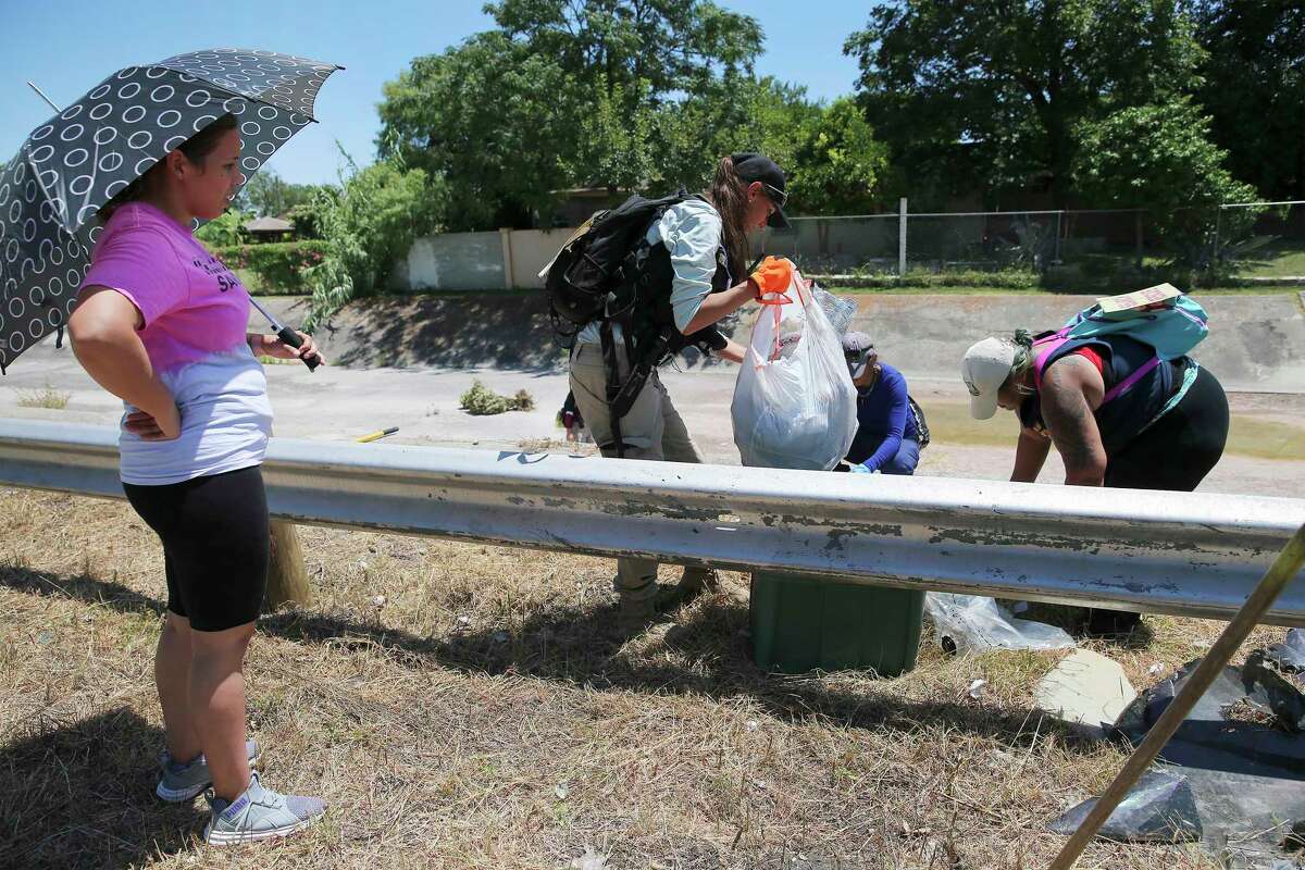 Mireya Lopez (from left) watches Search & Support San Antonio founder Nina Brooks, Monique Medina and Tiffany Reyna comb through some bags near a drainage ditch for clues while searching for Cecilia Huerta Gallegos on Saturday, July 27, 2019. Gallegos, 30, was last seen in the 5600 block of Southwick Street on July 8, according to the San Antonio Police Department. On Saturday, about a dozen searchers including Gallegos' sister Mireya Lopez of Houston went to six different locations in an effort to draw to a close the disappearance of the mother of four children. (Kin Man Hui/San Antonio Express-News)