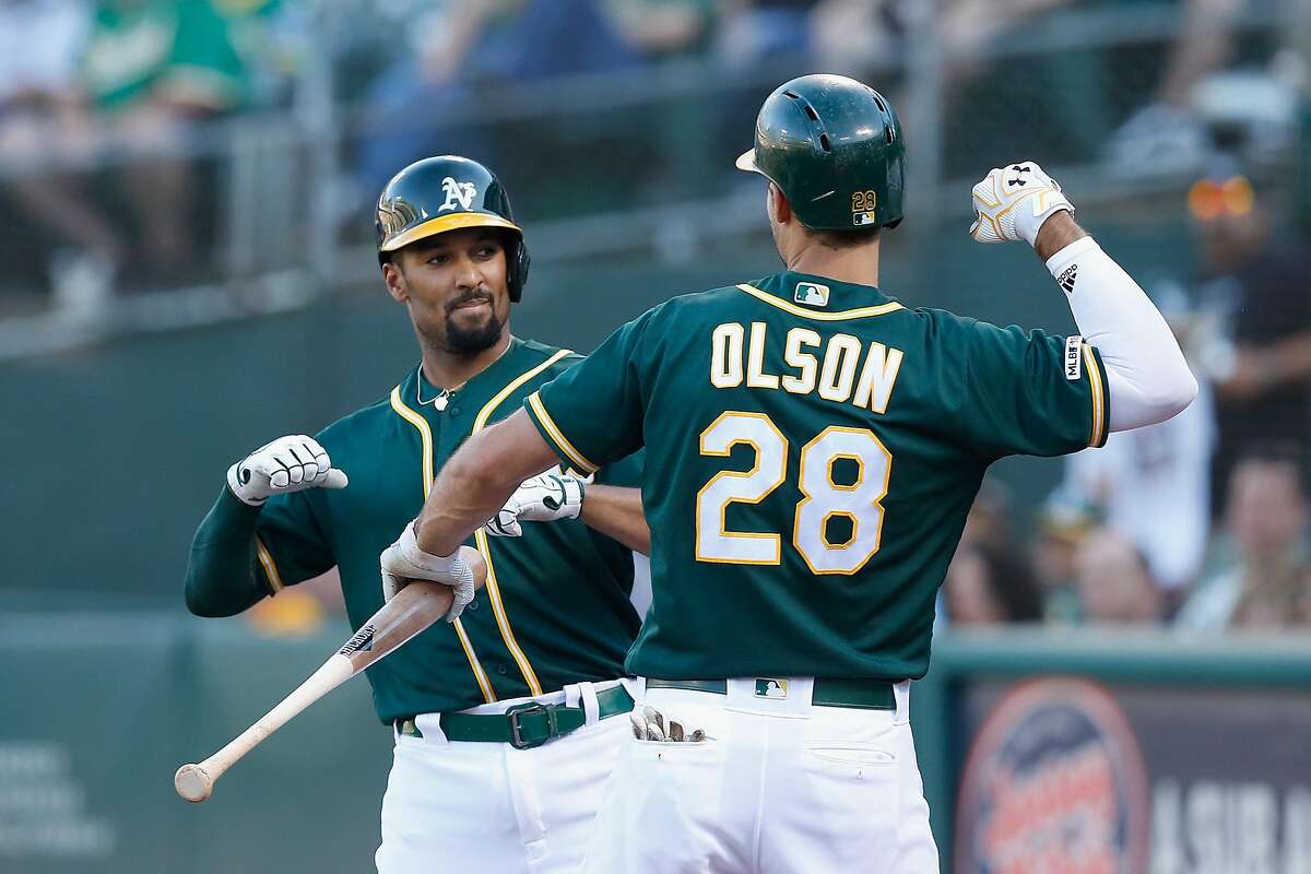 OAKLAND, CALIFORNIA - JULY 27: Marcus Semien #10 of the Oakland Athletics celebrates with Matt Olson #28 after hitting a solo home run in the bottom of the third inning against the Texas Rangers at Ring Central Coliseum on July 27, 2019 in Oakland, California. (Photo by Lachlan Cunningham/Getty Images)