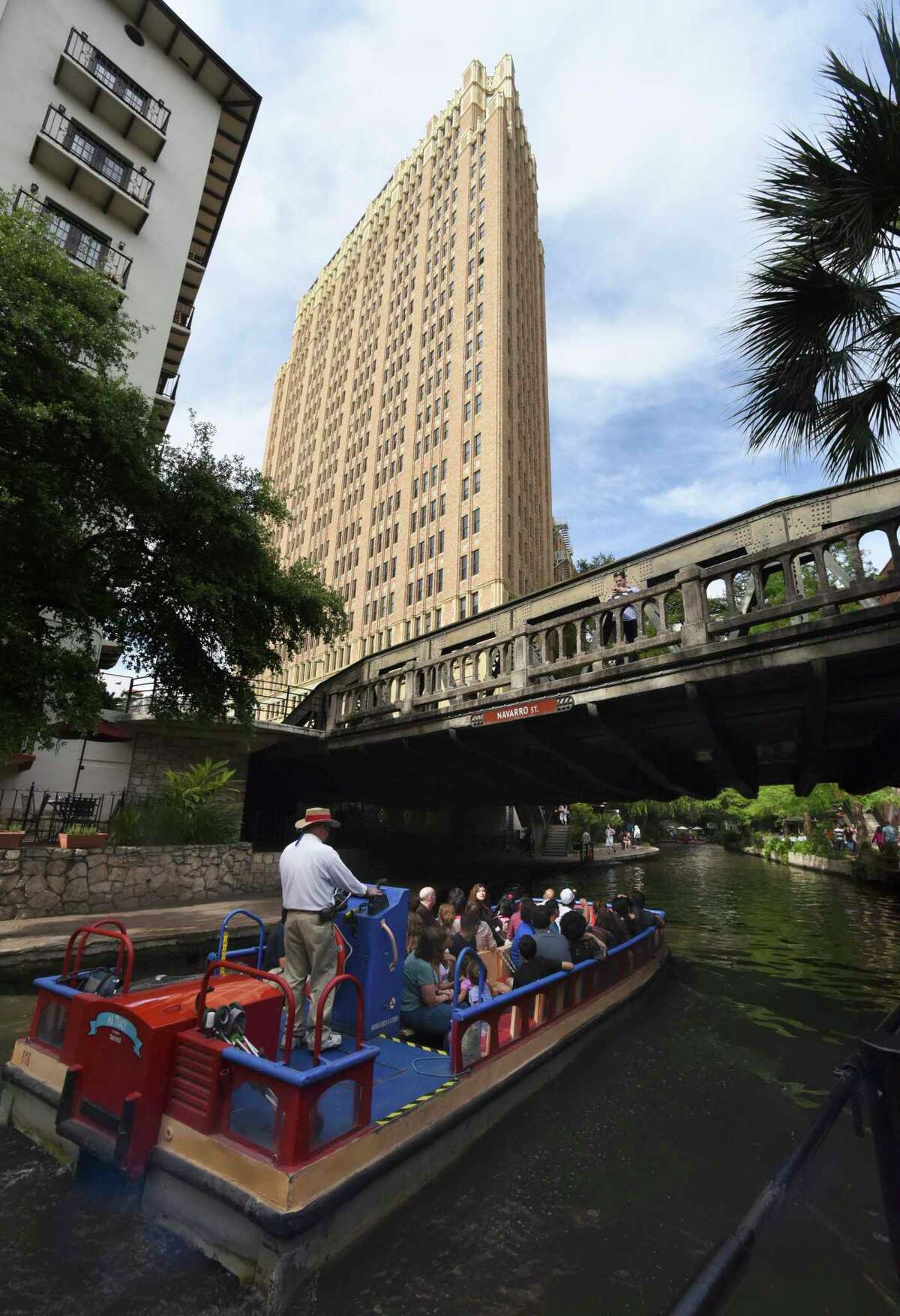 Nix Medical Center looms over a barge on the San Antonio River at the Navarro Street bridge in this 2015 photo.