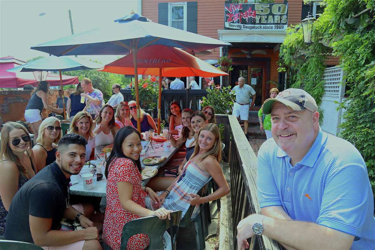 Co-owner Harry Brady, at right, poses with a large table of family and friends at the 50th anniversary celebration of Viva Zapata restaurant on Saturday, July 27, 2019, in Westport, Conn.