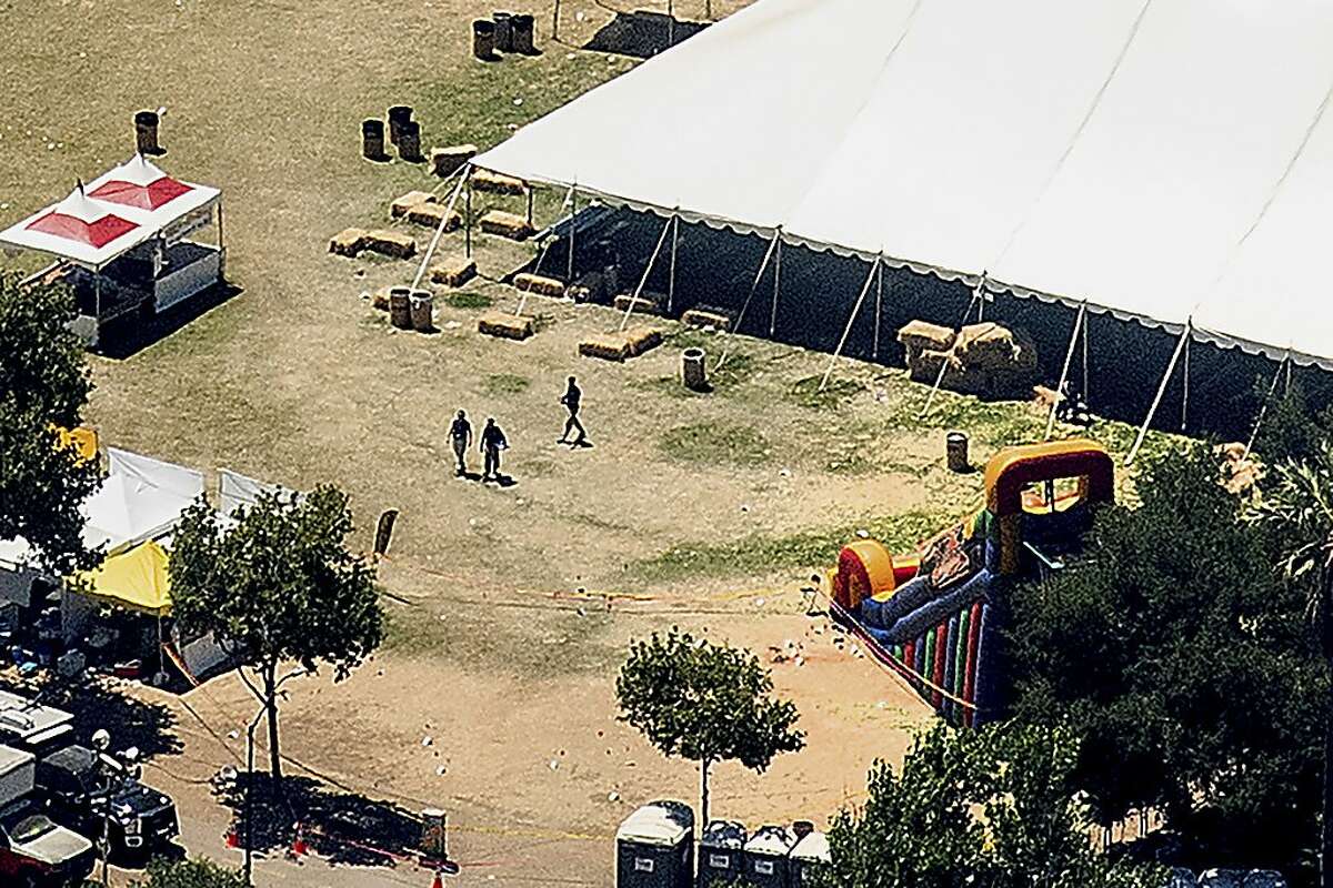 Investigators examine an area by an inflatable slide at Christmas Hill Park, the scene of Sunday's deadly shooting in Gilroy.