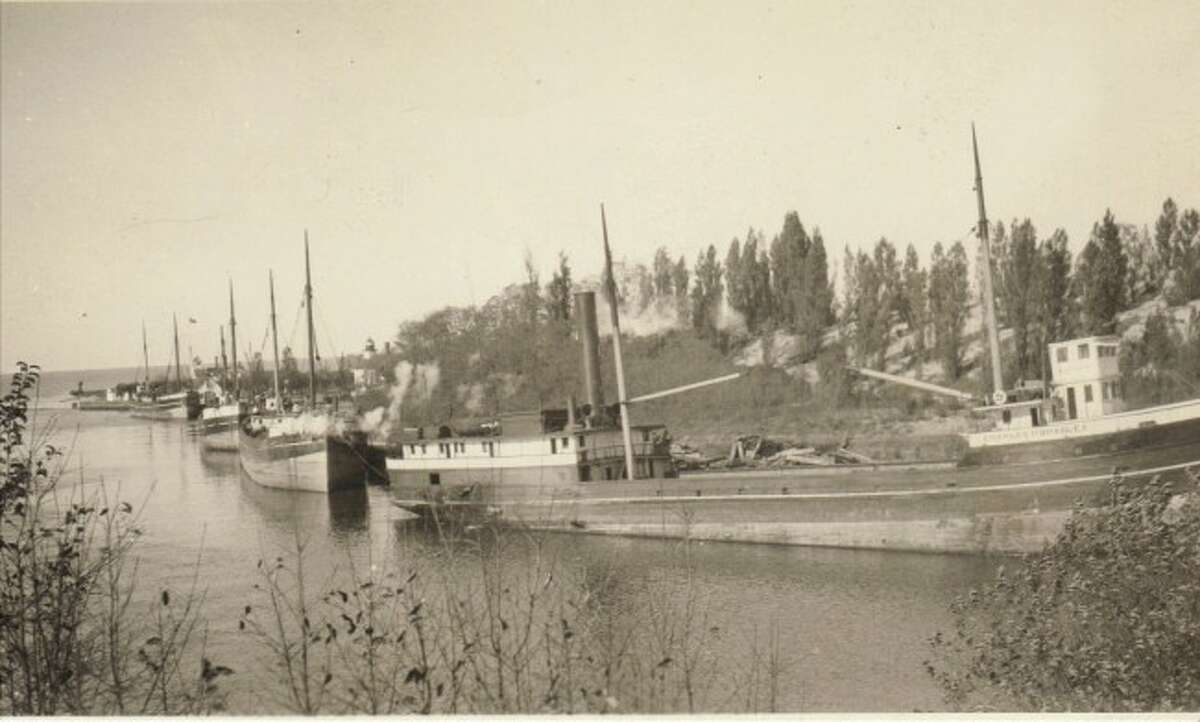 One of the main ways to transport goods made in Manistee in 1926 was with the use of schooners that are shown lining the Manistee River channel in this photograph.