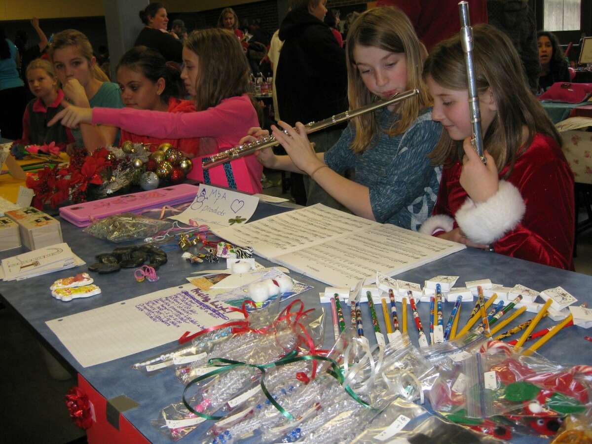 Abrielle Briske and Maddie Verheek provide music as well as the crafts that they are selling at the Kennedy Elementary School Handmade Gift Shop.