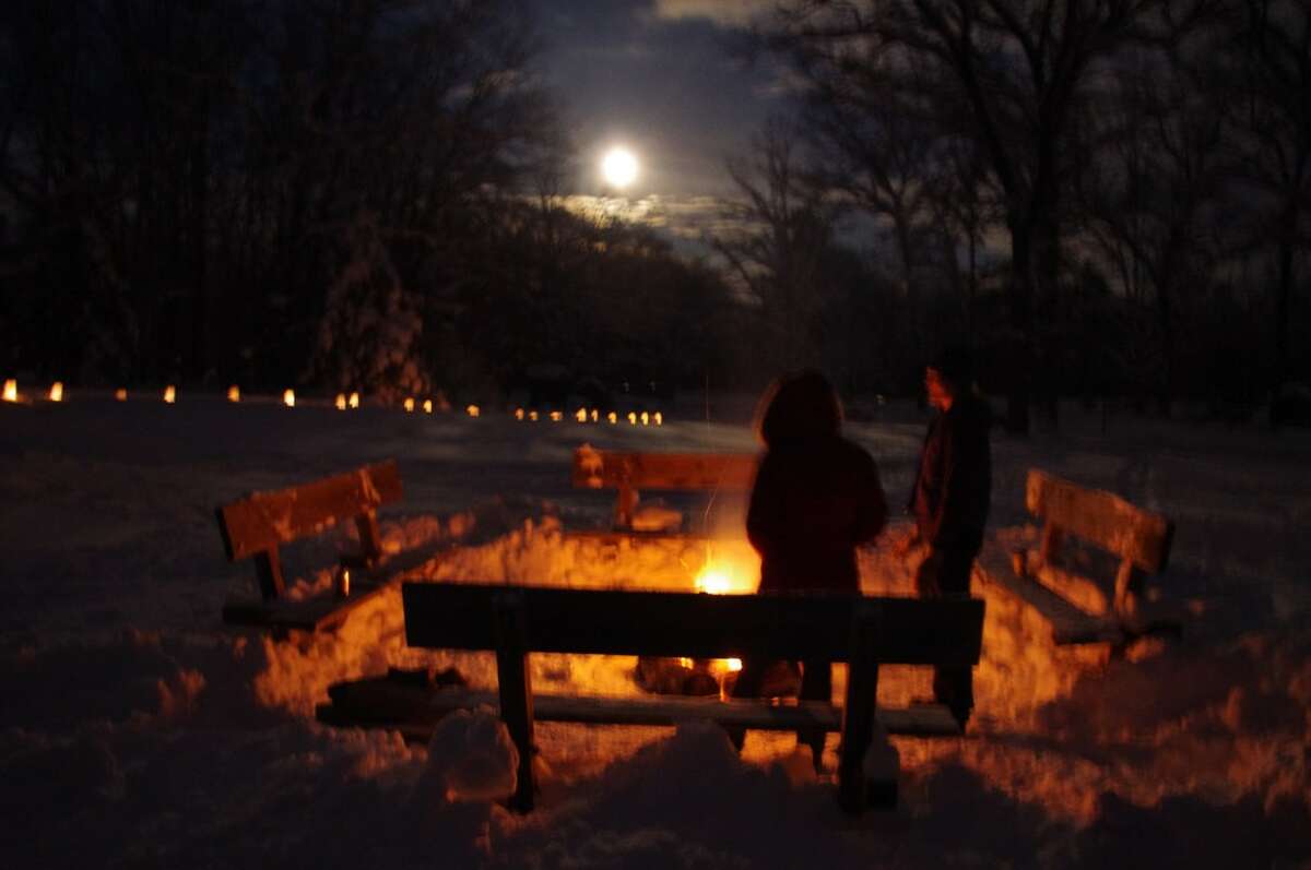 Skiers warm up at the outdoor fire pit as the moon rises over the Big M Cross Country Ski Area near Wellston. (Dave Yarnell/News Advocate)