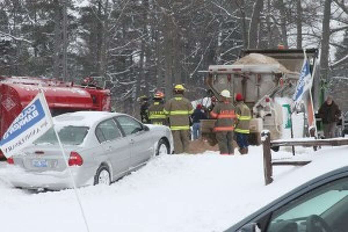Multiple vehicles, including a grey vehicle (pictured), had to veer into ditches to avoid hitting a tanker truck that rolled over on M-55 in Manistee Township Friday. (Sean Bradley/News Advocate)