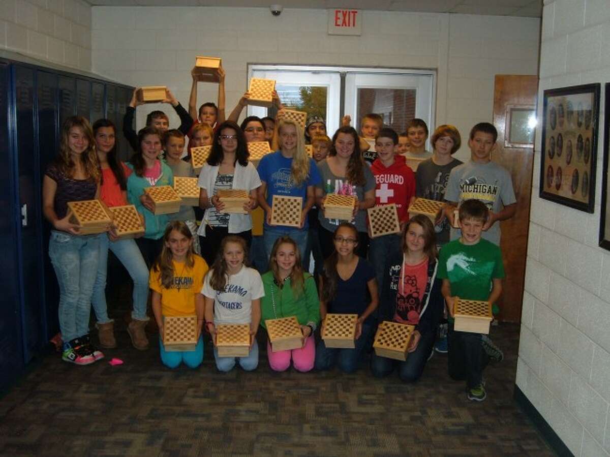 Middle school students from Onekama Consolidated Schools proudly show off the penny checker boxes they created in an exploratory wood shop class taught by Rex Toelle. Onekama is the last school district in the county to offer wood shop classes.