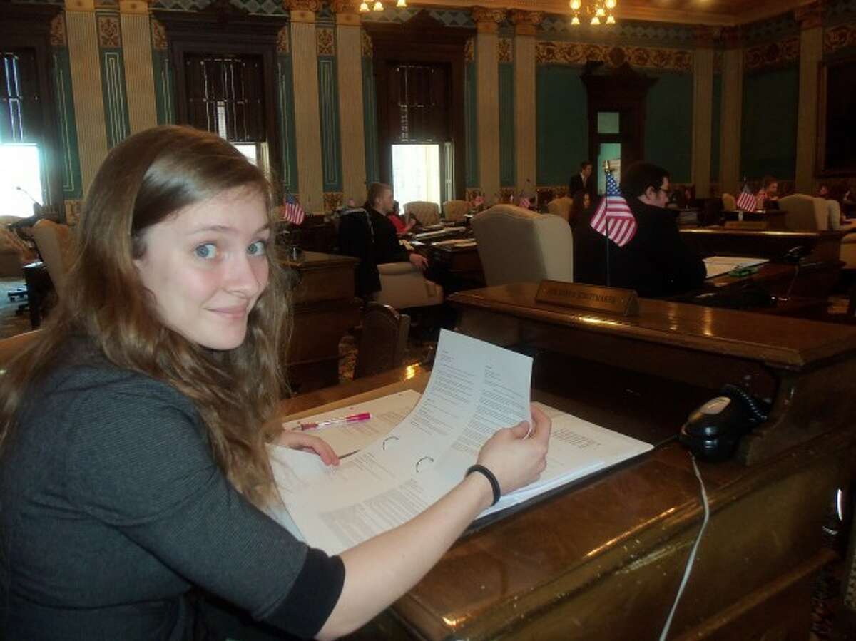 Former Manistee High School student Sarah Chandler who served in the Senate at Youth in Government last year takes a short break while reviewing some legislation that is being debated.