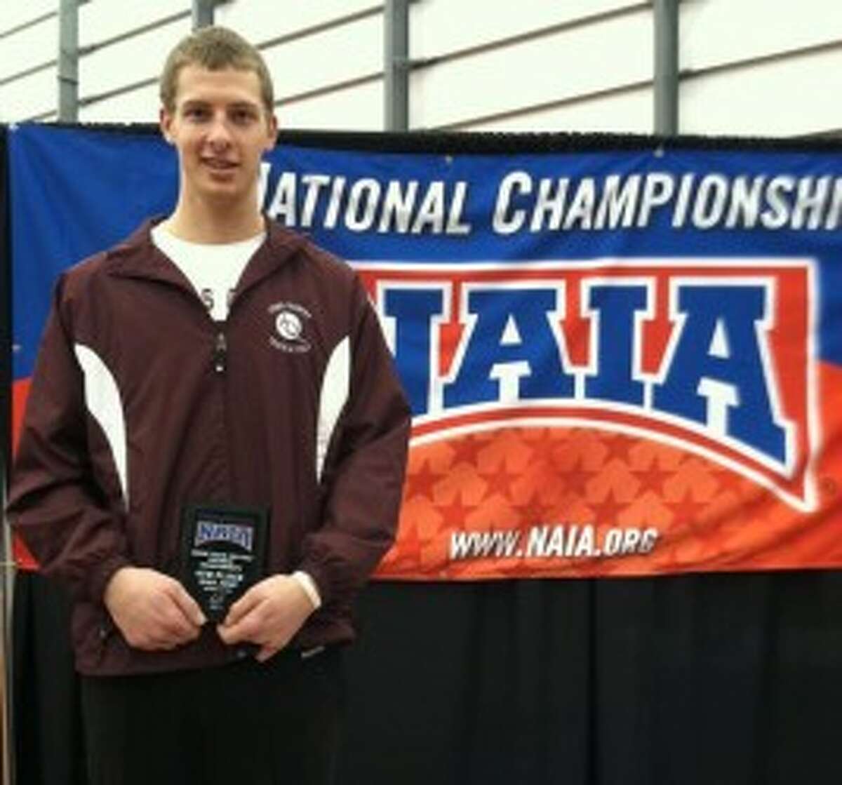 Ryan Helminiak poses with his fourth-place plaque from the 2012 NAIA Indoor National Championships. (Courtesy photo)