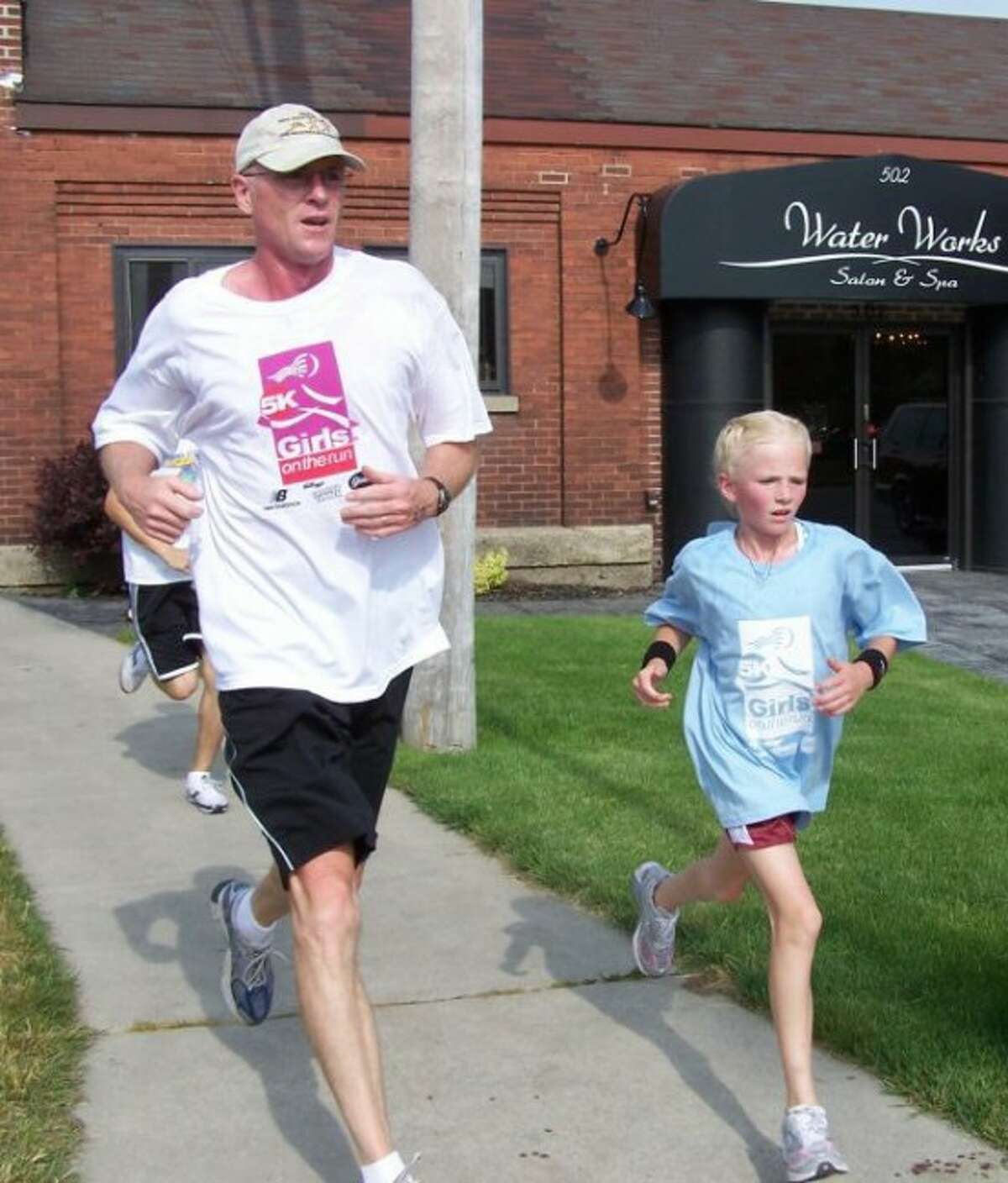 Annie Fuller runs with her dad, Craig Fuller.