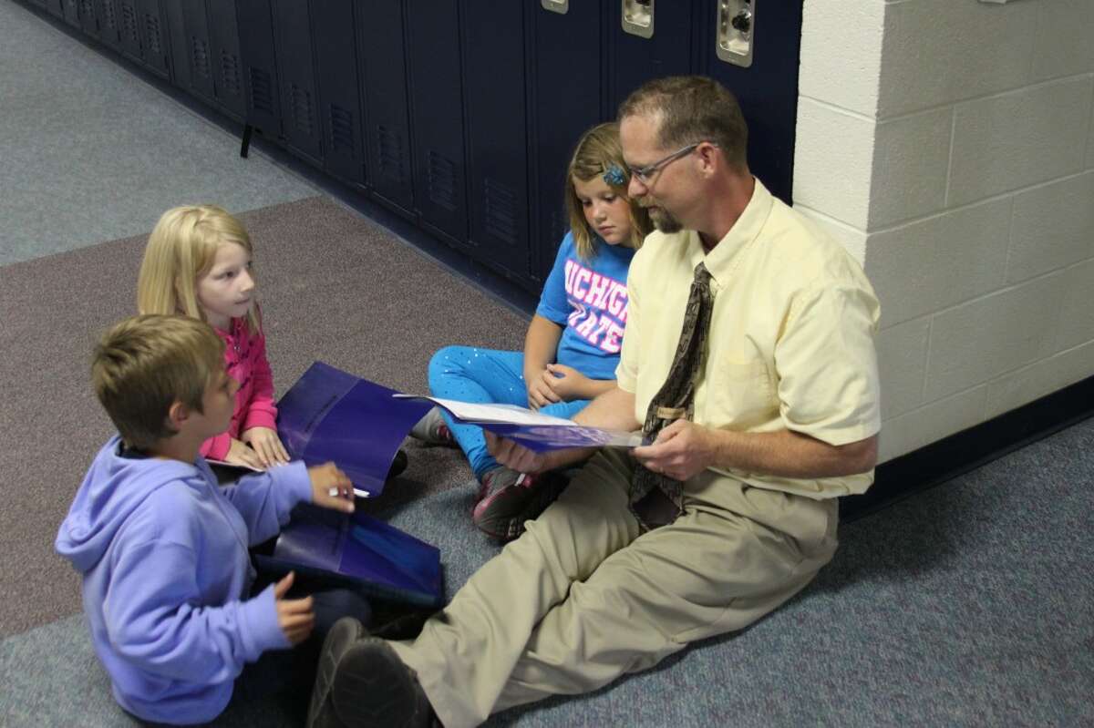 Jim Wojciechowski took over as principal at the Brethren Schools after spending the last 17 years as a teacher. The new principal is shown talking with some some the elementary students last week.