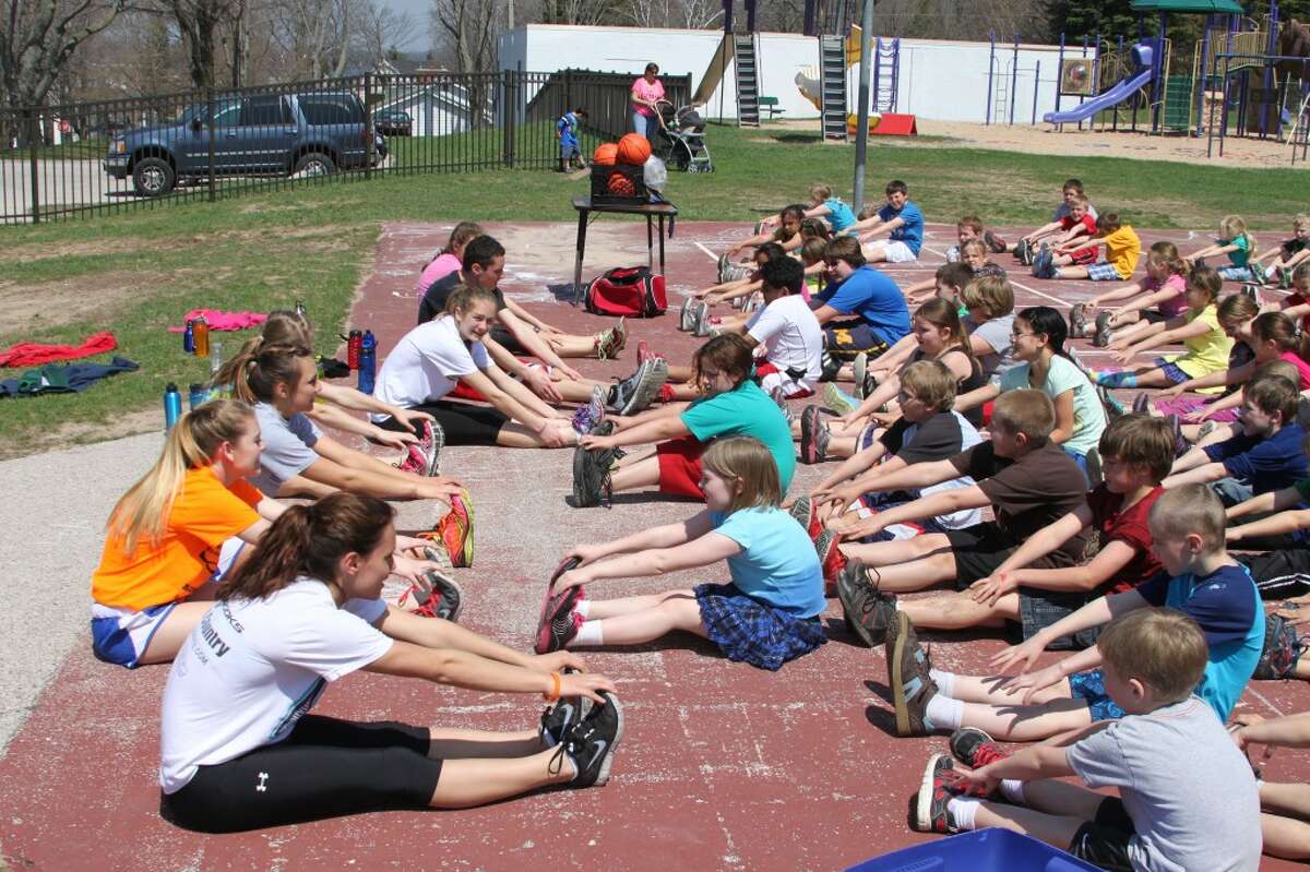 Members of the Bear Lake girls cross country state runner-up team lead the warm-up routine for the younger students prior to them running a mile as part of the All Children Exercising Simultaneously program.