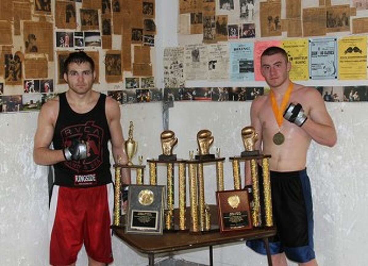 Tyler Bussell (right) and Randy Patino show off their Golden Gloves hardware after a sparring session on Sunday morning at the Manistee Boxing Club. (Matt Wenzel/News Advocate)