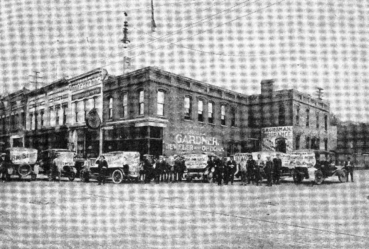 Cars bearing publicity banners for a Farmer’s Picnic at Orchard Beach were taken in a photo on the corner of River and Oak streets .The signs on the cars state in part that a beef barbeque was the main fare of the day.