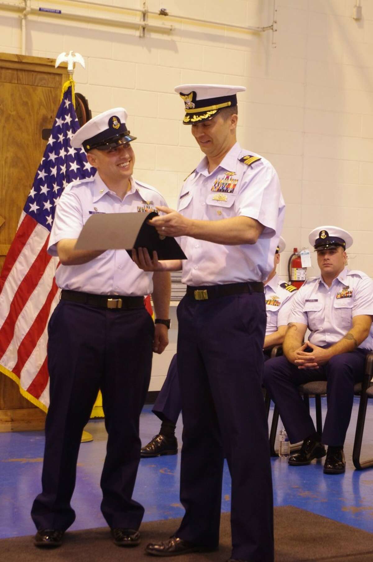 Commander Erik A. Leuenberger (right) presents a commendation medal to Chief Boatswain's Mate John L. Tribfelner on Friday at the Coast Guard Station Manistee change of command ceremony. (Dave Yarnell/News Advocate)