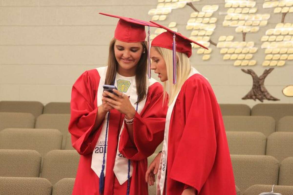 Manistee Catholic Central graduates Meghan Miller and Lauren Golembiewski look a photo they took prior to graduation on Friday evening. Diplomas were presented to 17 graduates on Friday night.
