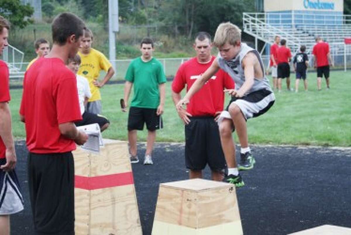 Taylor Bennett does box jumps during Wednesday’s Speed-e-Camp as instructors Jaron Llewellyn (left) and J.J. Randall look on. (Dylan Savela/News Advocate)
