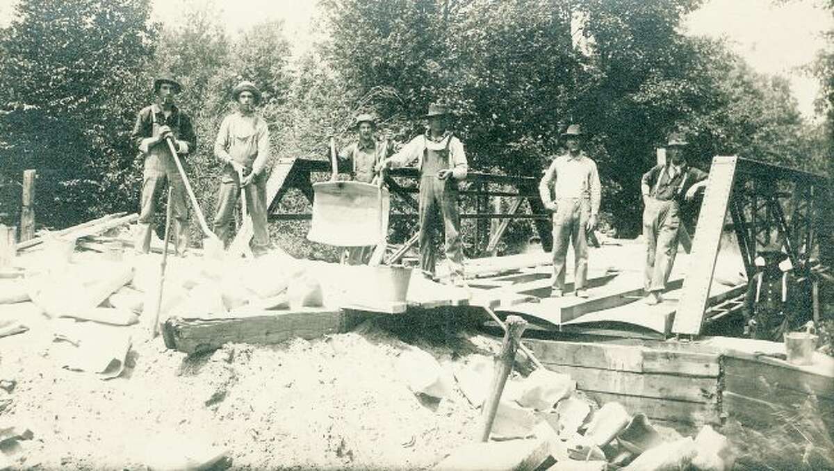 This early 1900 group of bridge builders work hard on fixing a bridge on one of Manistee's county roads.