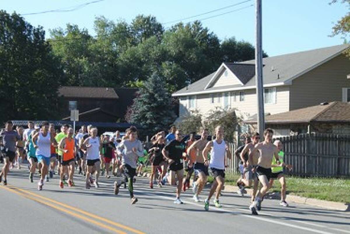 Runners take off from the start of the Onekama Days 5K on Saturday. (Ken Grabowski/News Advocate)