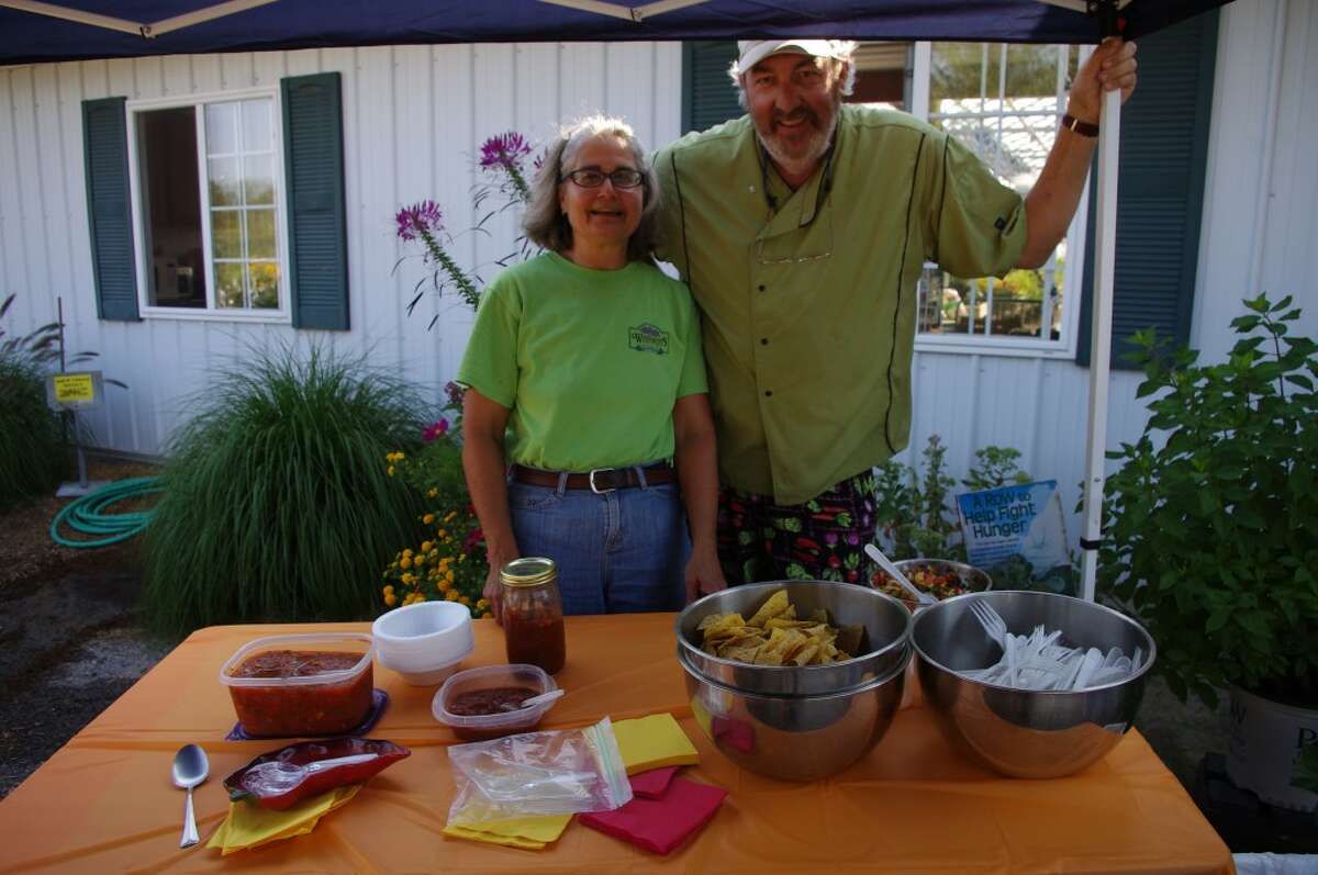 Marcie Grenmore of Weesies Brothers Garden Center and Al Frye of the Manistee Community Kitchen pose with the salsas Frye created with produce from the Manistee farmers market. (Dave Yarnell/News Advocate)