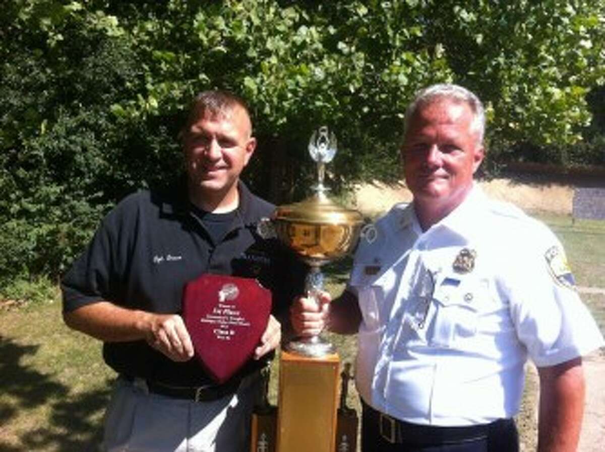 Manistee Police Chief Dave Bachman (right) holds his “Governor’s Cup” trophy for being the best shot in his division at the recent police shooting contest. Teammate Sgt. Tom Bruce stands to his left. (Courtesy photo)