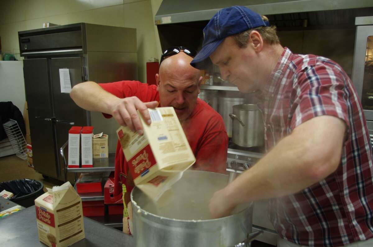 Jim Naffie (left) and Joe Bigalke make the mashed potatoes for the Bette Naffie Memorial Annual Community Thanksgiving Dinner, which was served Thursday at the Manistee VFW Hall. (Dave Yarnell/News Advocate)