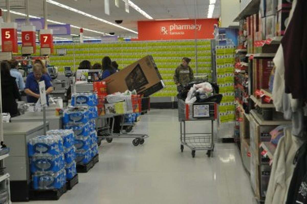 A shopper checks out with a shopping cart full of discounted items, including a big-screen TV.