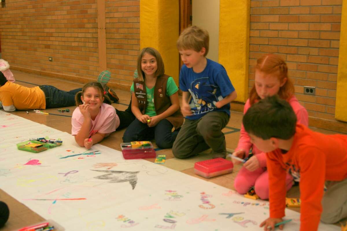 Jefferson Elementary School students brought the sidewalks inside to take part in the Paint the Town Pink event this year. Rainy weather prevented them from coloring the sidewalks on River Street the day of the walk so they opted for rolling out paper in the gymnasium to do the same thing. (Courtesy photo)