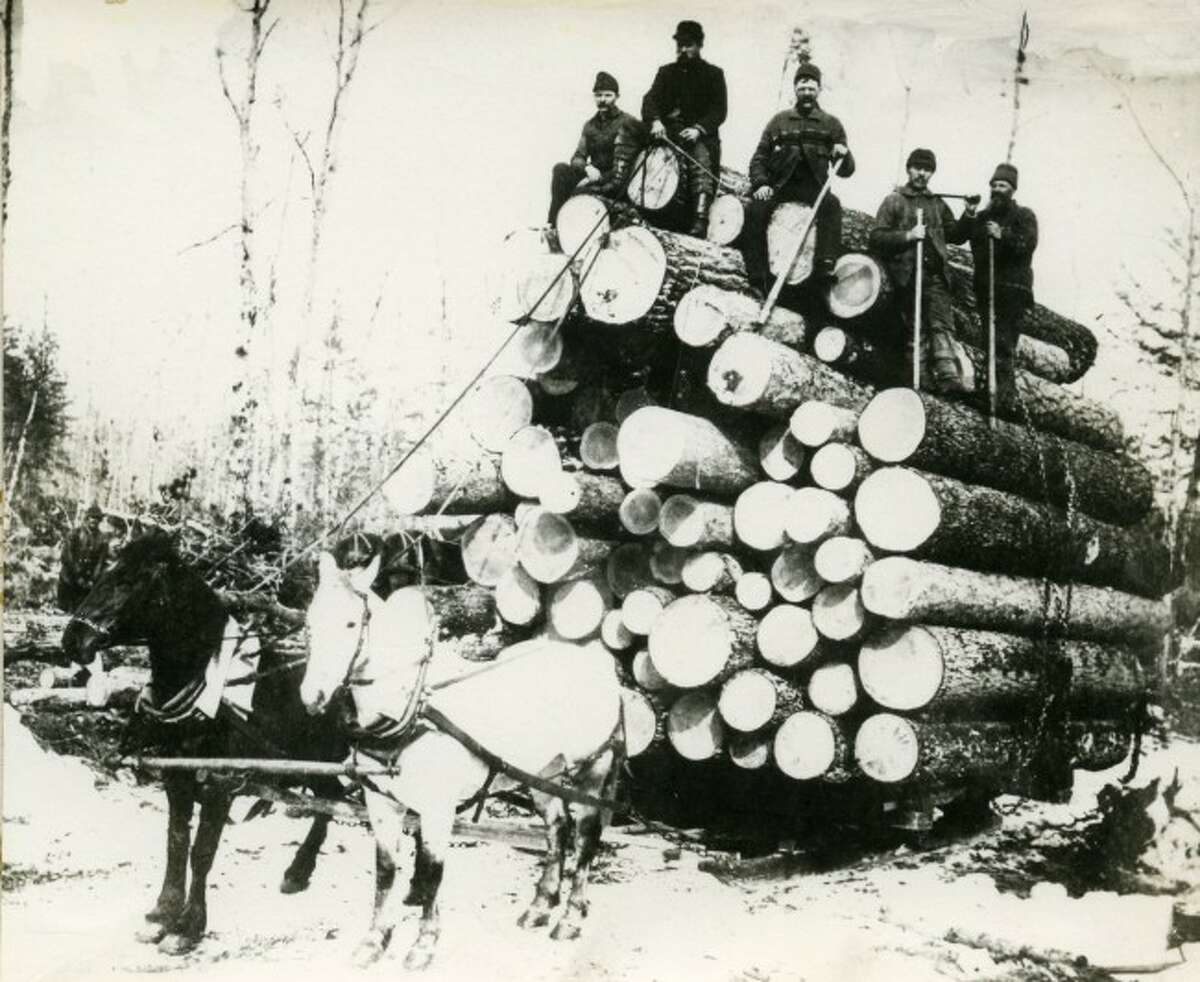 This group of lumberjacks load up a huge bunch of logs ready to ship them to the mill.