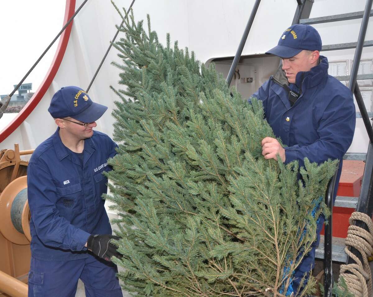 Seaman Miles Beck (left) and Petty Officer 2nd Class Zack Emery of the Coast Guard Cutter Mackinaw, arrange one of the 1, 300 Christmas trees brought to Chicago for distribution to deserving families. The Mackinaw served as this year’s Christmas Ship on the 100th anniversary of the sinking of the Rouse Simmons, the original Christmas Ship, off of two Rivers, Wis. (Courtesy Photo/Chief Petty Officer Alan Haraf)