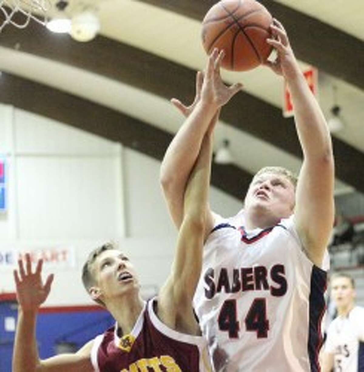 MCC’s Andrew Perry battles for a rebound with NMC’s John Brouwer. (Matt Wenzel/News Advocate)