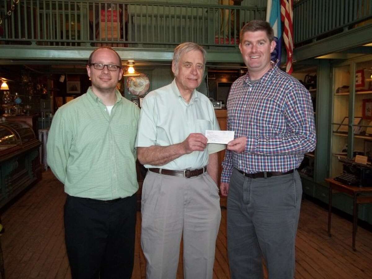 Mark Fedder and Steve Harold of the Manistee County Historical Society receive a donation check from Dennis P. McCarthy.