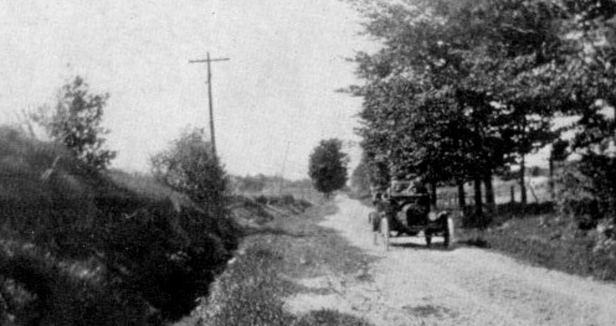 A car makes it way along a county road in this picture from the late 1920s.