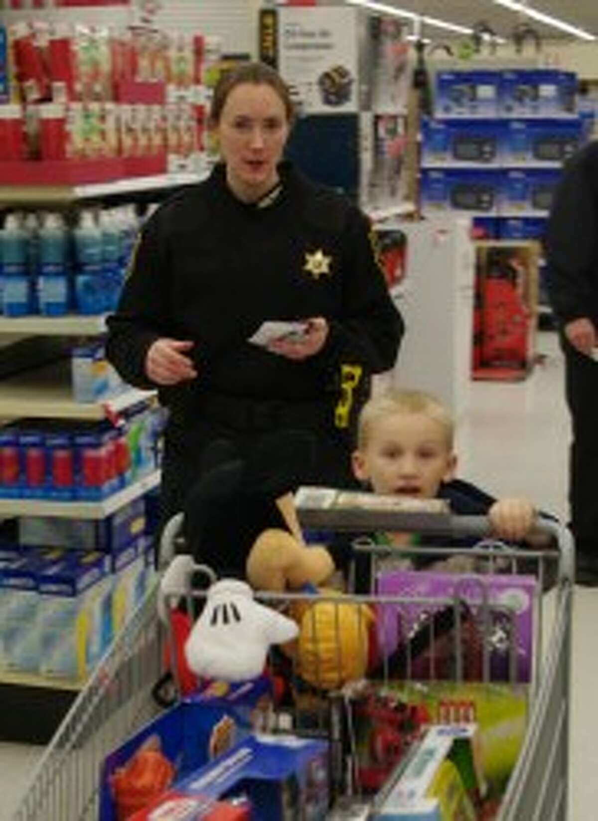 Blake Somsel pushes the cart as Ella Simmons of the Manistee County Sheriff’s Department follows. (Dave Yarnell/News Advocate)