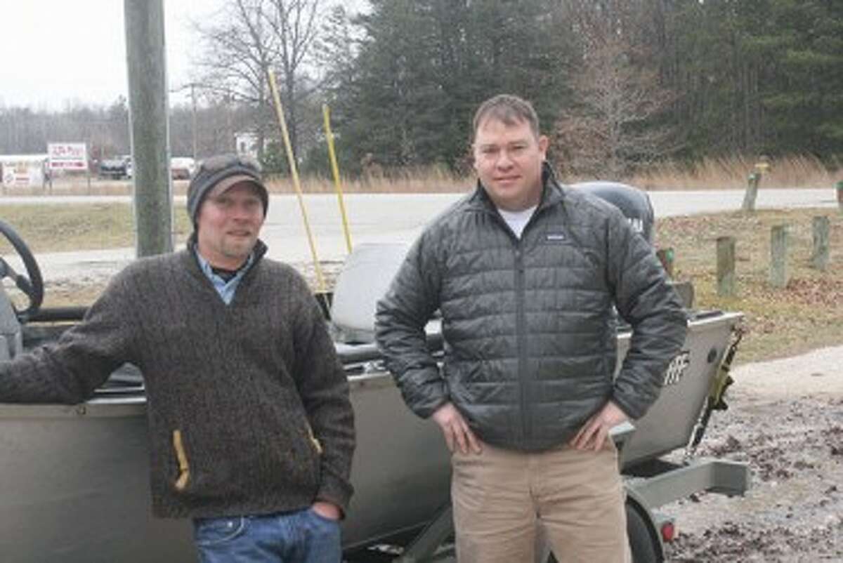 Brent Borcherdt (left), standing with Schmidt Outfitters owner Paul Transue, gets ready for another fishing trip. (John Raffel/Pioneer News Network)