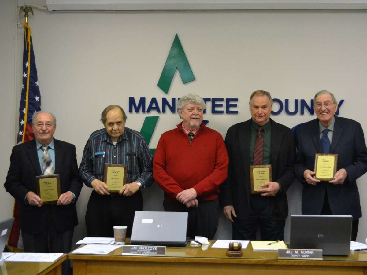 County commission chair Jim Krolczyk (center) awards commemorative plaques to four retiring commissioners: from left, Glenn Lottie, Carl Rutske, Duane Anderson, and Erv Kowalski. (Meg LeDuc/News Advocate)