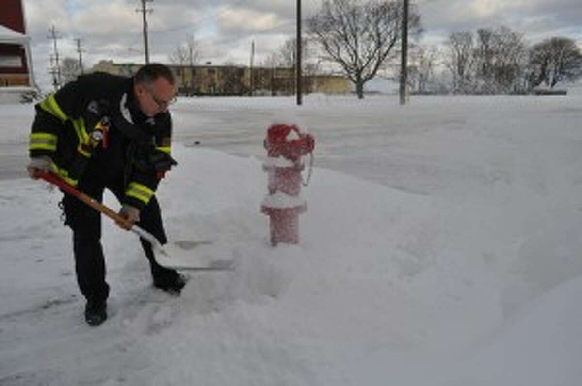 Manistee Fire Department Capt. Doug Dominick removed snow from around fire hydrants on Thursday.
