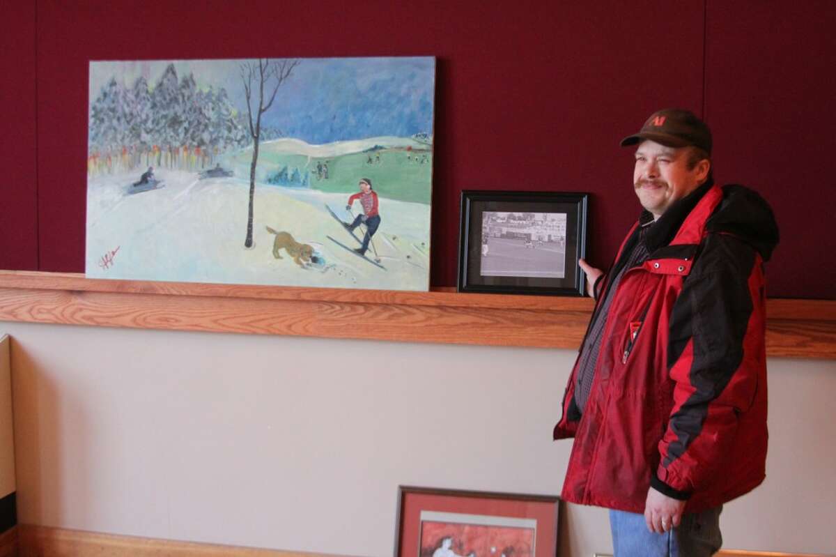 Steve Mellott owner of the Living Studio Design sees how his photograph looks in a display at the T. Walter Hardy Hall of the Ramsdell Theatre. They show All Art Olympics opens on Friday March 8 with the artists reception from 6 to 8:30 p.m. (Ken Grabowski/News Advocate)