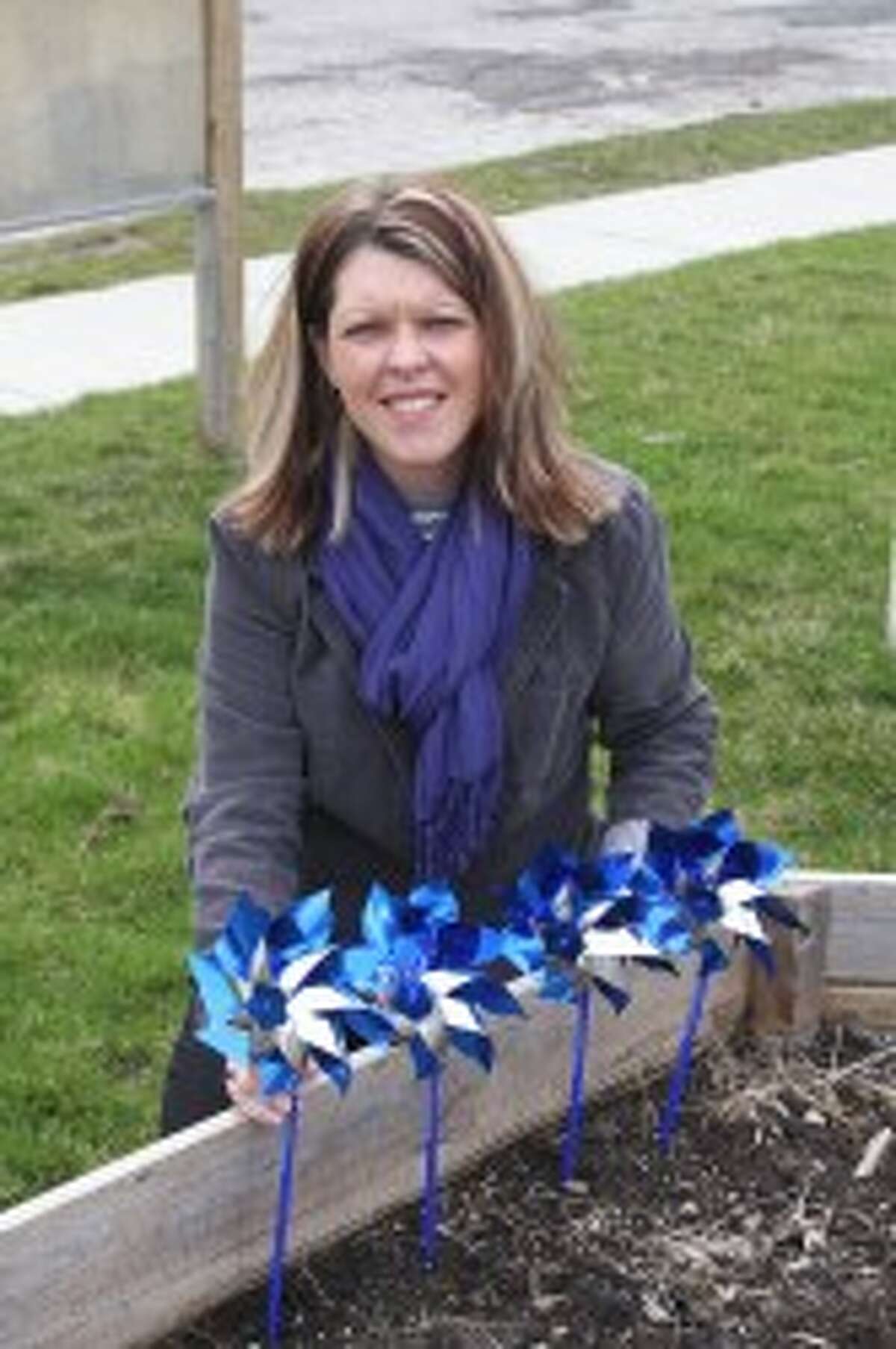The Manistee Child Advocacy Center’s Traci Smith places some of the blue pinwheels that are various locations around town for the Pinwheels for Prevention program and Child Abuse Prevention Month. The center is sponsoring a walk at 1 p.m. on Sunday, April 28 as a fundraiser for the Manistee Child Advocacy Center.(Ken Grabowski/News Advocate)