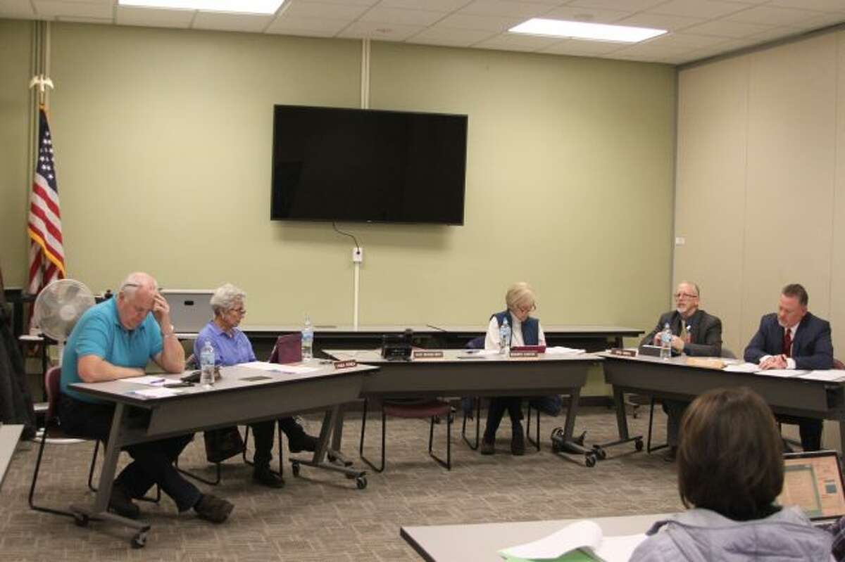 Manistee Intermediate School District Board of Education members listen to superintendent Dave Cox (far right) give a report on the Raising Tide meeting.