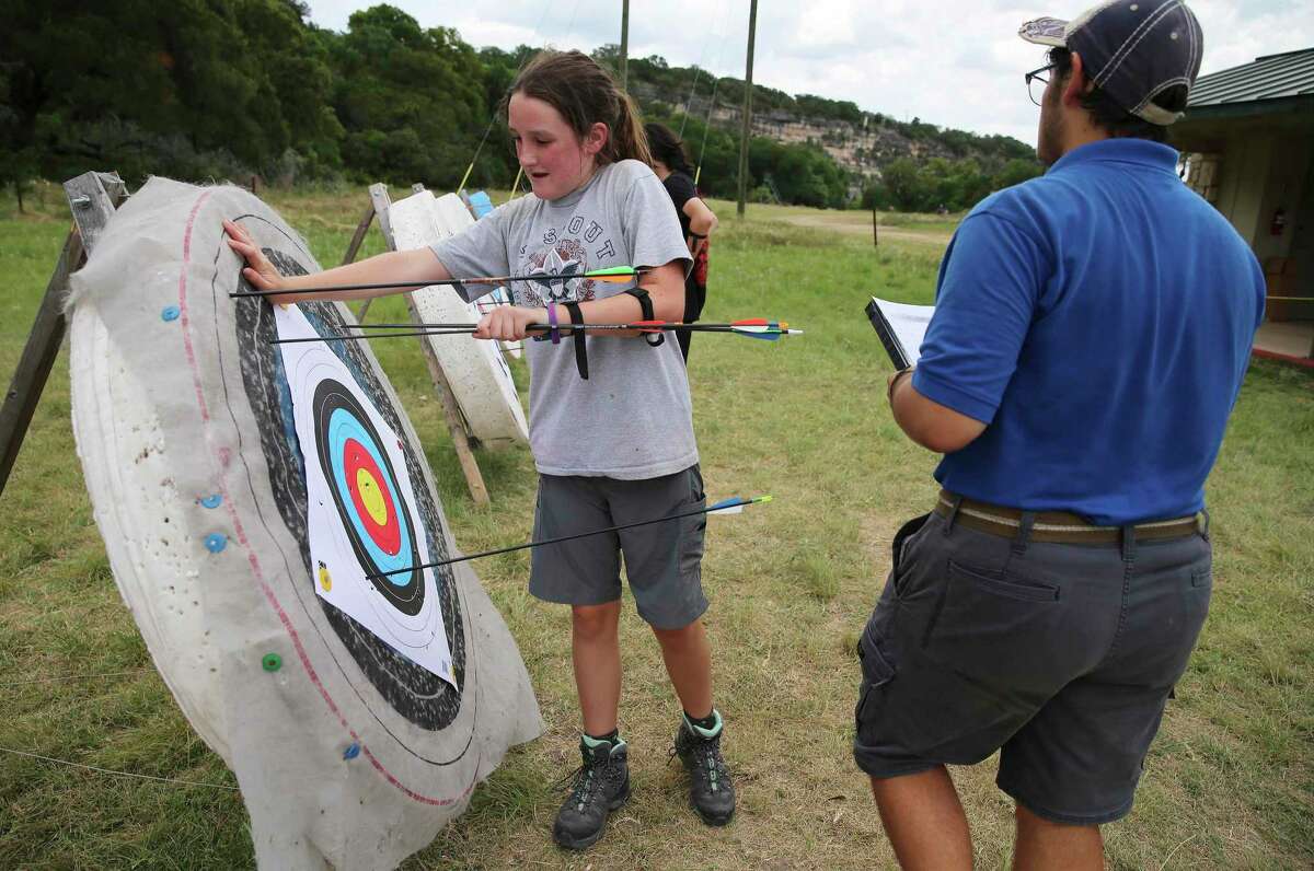 Abbey Muenchow, 13, retrieves her arrows from a target while competing in archery during a campwide scouting competition at Bear Creek Scout Reservation near Hunt on July 12, 2019.