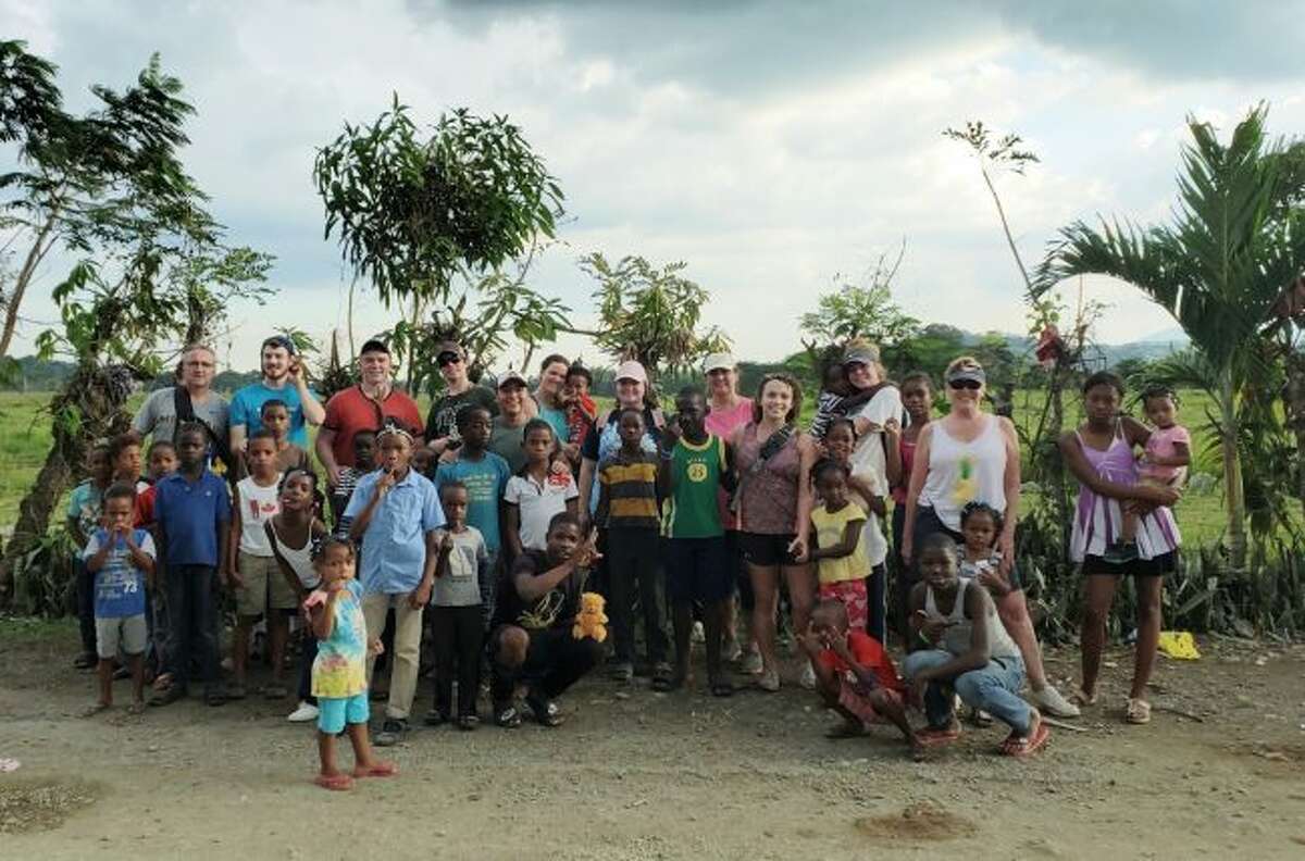 The Rotary International group from Manistee pose with the children of Villa Altagracia where they worked on one of their projects.