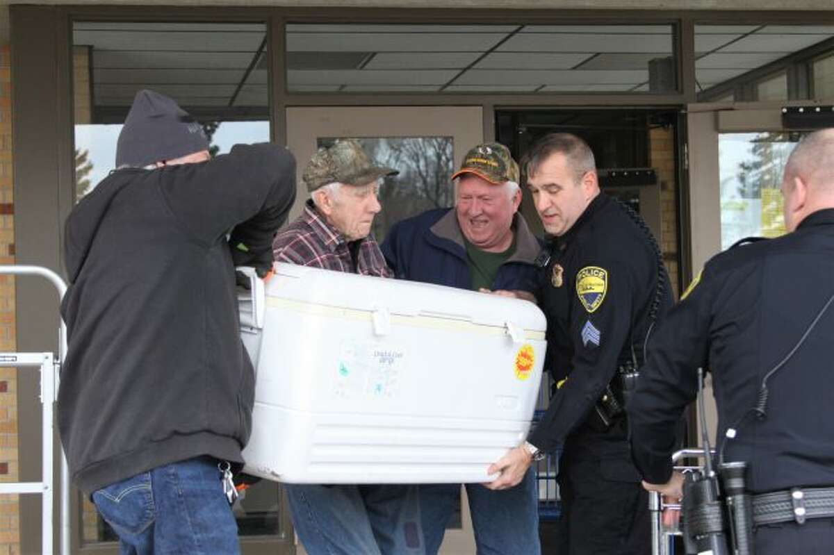 Officers help unload donated venison at the Matthew 25:35 food pantry, which is located at the Divine Mercy Parish Center in Manistee. (Ashlyn Korienek/News Advocate)