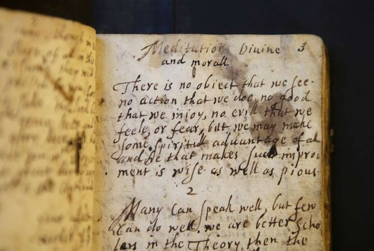 In this Wednesday, March 20, 2019, photo provided by the Board of Trustees of Stevens Memorial Library, a handwritten manuscript called "Meditations Divine and Moral," by 17th century poet Anne Bradstreet, rests on a table at the Houghton Library on the campus of Harvard University, in Cambridge, Mass. Bradstreet was the North American continent's first published poet. Her actual burial place is not known. (Courtesy of Board of Trustees of Stevens Memorial Library via AP)